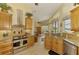 Open kitchen with wooden cabinets, granite counters, stainless appliances, and water views at 410 Wellington, Venice, FL 34292