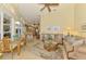 Bright living room featuring stylish furniture, a ceiling fan, and an open layout to the kitchen and dining area at 410 Wellington, Venice, FL 34292