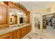 Elegant primary bathroom with dual sinks, wood cabinets, and a view to the main bedroom at 410 Wellington, Venice, FL 34292