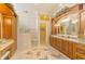 Luxurious main bathroom featuring dual sinks, a vanity, and a walk-in shower with a built-in bench at 410 Wellington, Venice, FL 34292