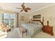 Relaxing main bedroom with a decorative ceiling fan, king bed, and views of the lake at 410 Wellington, Venice, FL 34292