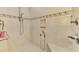 Close-up of a tiled walk-in shower with a built-in bench and dual shower heads at 410 Wellington, Venice, FL 34292