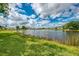 View of waterfront property with lush green lawn and blue sky at 410 Wellington, Venice, FL 34292