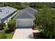 Aerial view of a gray single-Gathering home with lush landscaping and a driveway at 4318 Deep Creek Ter, Parrish, FL 34219