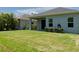 Backyard featuring a covered patio, lush green lawn, and privacy landscaping at 4318 Deep Creek Ter, Parrish, FL 34219