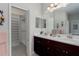 Bathroom featuring double vanity, a large mirror and a walk-in closet at 4318 Deep Creek Ter, Parrish, FL 34219