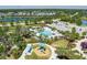 Aerial view showcasing a community pool, playground, and recreational area surrounded by mature trees at 4318 Deep Creek Ter, Parrish, FL 34219