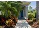 Charming home featuring a brightly colored front door framed by lush, tropical landscaping at 4318 Deep Creek Ter, Parrish, FL 34219