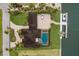 Aerial view of home with a private pool, paver driveway, mature tropical landscaping, and private boat dock at 4355 Pompano Ln, Palmetto, FL 34221
