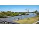 Backyard view of a tranquil waterfront with a boat dock, mature trees, and a well-maintained lawn at 4355 Pompano Ln, Palmetto, FL 34221