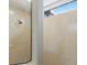 Shower with beige tiled walls, decorative diamond inset tile, and glass doors to complete the modern design at 4355 Pompano Ln, Palmetto, FL 34221