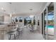 Bright dining area featuring a kitchen island with bar stools, a glass table, and a view of the pool at 4355 Pompano Ln, Palmetto, FL 34221