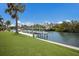 Lush lawn leads to a private boat dock on a calm waterway under a sunny sky at 4355 Pompano Ln, Palmetto, FL 34221