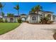 Beautiful two-story home with a paved circular driveway and portico surrounded by palm trees and tropical landscaping at 4355 Pompano Ln, Palmetto, FL 34221