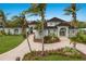 Elegant two-story waterfront home with lush landscaping and a circular brick driveway lined with palm trees at 4355 Pompano Ln, Palmetto, FL 34221