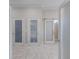 Hallway with neutral tile floor and three doors, including one with a sliding door at 4355 Pompano Ln, Palmetto, FL 34221