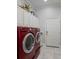Laundry room featuring side by side red washer and dryer with overhead cabinets at 4355 Pompano Ln, Palmetto, FL 34221