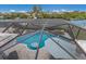 Aerial view of screened-in pool area featuring a custom rock waterfall feature, and sun umbrella at 4355 Pompano Ln, Palmetto, FL 34221