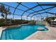 Screened-in pool area, a built-in rock waterfall feature, umbrella, and comfortable seating at 4355 Pompano Ln, Palmetto, FL 34221