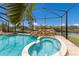Gorgeous pool and spa feature a rock waterfall, surrounded by a screened enclosure at 4355 Pompano Ln, Palmetto, FL 34221