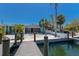 Waterfront home with a dock and screened in porch with palm trees at 444 63Rd St, Holmes Beach, FL 34217