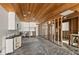 Kitchen and living room featuring unfinished walls, white cabinets, ceiling fan and wood plank ceiling at 444 63Rd St, Holmes Beach, FL 34217