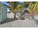 Landscaped backyard featuring a shed, white vinyl fence and tropical plants on a pebble ground cover at 4440 Yacht Club Dr, Venice, FL 34293