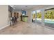 Entertaining area with bar seating, television, and sliding glass doors leading to the pool at 4440 Yacht Club Dr, Venice, FL 34293