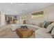 Spacious living room with plush sectional, travertine flooring, and view of outdoor greenery at 4440 Yacht Club Dr, Venice, FL 34293