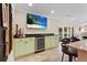 A wet bar features a wine chiller, granite countertop and flat screen TV at 4440 Yacht Club Dr, Venice, FL 34293