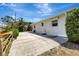 Long, spacious driveway alongside the home with mature landscaping, and a partial wooden fence at 519 Bayview Ave, Osprey, FL 34229