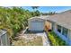 Features a detached garage with a roll-up door surrounded by lush landscaping and a brick pathway at 519 Bayview Ave, Osprey, FL 34229