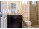 Modern bathroom with dark vanity, neutral countertop, glass shower door, and white fixtures at 5502 Tidewater Preserve Blvd, Bradenton, FL 34208