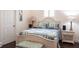 Bedroom features a bed with blue striped comforter, matching ottoman, and bedside lamps at 5502 Tidewater Preserve Blvd, Bradenton, FL 34208