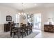 Elegant dining room featuring a large table, chandelier, and sliding glass doors to a screened patio at 5502 Tidewater Preserve Blvd, Bradenton, FL 34208