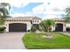 Elegant two-story home featuring a tile roof, manicured lawn, and a two-car garage at 5502 Tidewater Preserve Blvd, Bradenton, FL 34208