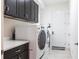 Convenient laundry room with modern washer and dryer, cabinets, and ample counter space at 5502 Tidewater Preserve Blvd, Bradenton, FL 34208