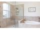 Luxurious bathroom with a glass-enclosed shower and a soaking tub with tile surround at 5502 Tidewater Preserve Blvd, Bradenton, FL 34208
