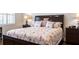Cozy bedroom with a decorative floral comforter, bedside tables, and a window with blinds at 5502 Tidewater Preserve Blvd, Bradenton, FL 34208