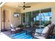 Cozy covered patio with comfortable seating, a TV, and views of the surrounding landscape at 5502 Tidewater Preserve Blvd, Bradenton, FL 34208