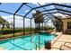 Stunning pool and spa area with screened enclosure, beautiful landscaping, and serene lake views for ultimate relaxation at 5502 Tidewater Preserve Blvd, Bradenton, FL 34208