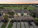 Aerial shot of a condominium complex showcasing tile roofs, multiple garages, and proximity to a golf course at sunset at 5528 Palmer Cir # 204, Lakewood Ranch, FL 34211