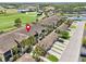 Aerial view of condo building with golf course and pond nearby, featuring tiled roof and well-manicured landscaping at 5528 Palmer Cir # 204, Lakewood Ranch, FL 34211