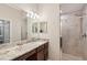 This bathroom features a beautiful vanity with marble countertops and a tiled shower at 5528 Palmer Cir # 204, Lakewood Ranch, FL 34211