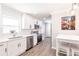 Bright kitchen with white cabinets, stainless steel appliances, and wood-look flooring at 6009 Lords Ave, Sarasota, FL 34231