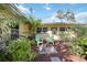 Charming backyard featuring a cozy fire pit with chairs and lush tropical landscaping at 610 Poinsettia Rd, Nokomis, FL 34275