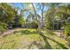 Expansive backyard with mature trees and a large grassy area, perfect for outdoor activities at 610 Poinsettia Rd, Nokomis, FL 34275