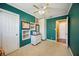 Green bedroom featuring built-in shelving, a ceiling fan, and dual closets for ample storage at 610 Poinsettia Rd, Nokomis, FL 34275