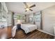 Cozy bedroom with wood floors, neutral walls, and natural light from two large windows at 610 Poinsettia Rd, Nokomis, FL 34275