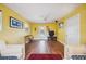 Sunny living room featuring warm yellow walls, hardwood floors, and cozy seating arrangements at 610 Poinsettia Rd, Nokomis, FL 34275